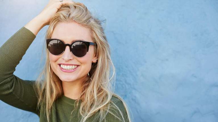 A smiling woman with sunglasses | dentist Coffs Harbour