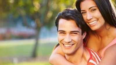 Smiling couple in the park | Dental Implants Coffs Harbour, NSW