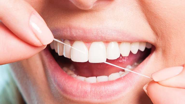 A person flossing | Invisalign Coffs Harbour