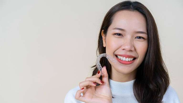 Woman holding an invisalign tray | Coffs Harbour Dentist