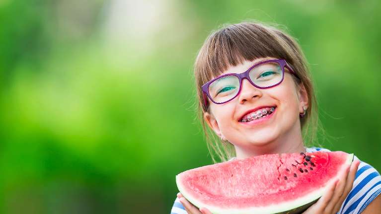 Child with braces eating watermelon in Coffs Harbour